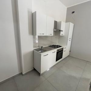 a white kitchen with a sink and a stove at Casa vacanze joppolo in Ioppolo