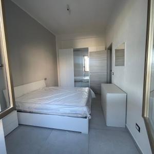 a small bedroom with a white bed and a bathroom at Casa vacanze joppolo in Ioppolo