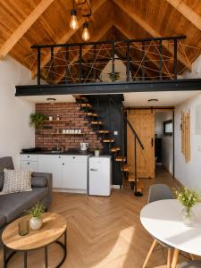 a loft kitchen and living room with a spiral staircase at Osada Przejrzysko in Jordanów