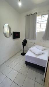 a small room with a bed and a mirror at Pousada Só Alegria in Fortaleza