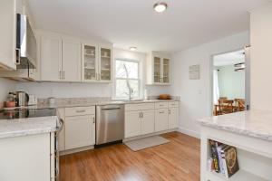 a kitchen with white cabinets and a wooden floor at Just For the Halibut in Rockport