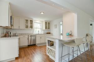 a kitchen with white cabinets and a counter with stools at Just For the Halibut in Rockport