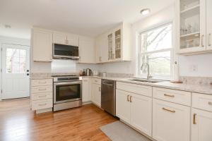 a kitchen with white cabinets and stainless steel appliances at Just For the Halibut in Rockport