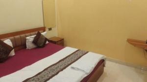 a bedroom with a large bed with white and red sheets at guest house honey haldwani in Haldwāni