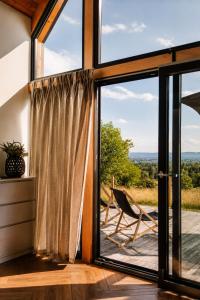 a room with a large window and a chair at Osada Przejrzysko in Jordanów