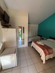 a large room with two beds and a television at Pousada Rubbi Violeta in Alto Paraíso de Goiás