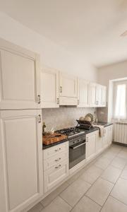 a kitchen with white cabinets and a stove top oven at Da nonno Carlo Lakeview - By BorgoLago in Capodimonte