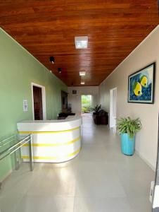 a large hallway with a lobby with a wooden ceiling at Hotel Vitoria in Matupá