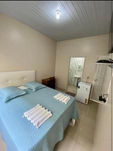 a bedroom with a blue bed with white pillows on it at Hotel Vitoria in Matupá