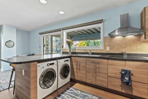 a kitchen with a washing machine and a sink at Spa Creek Condo Pool Deck & Parking in Annapolis