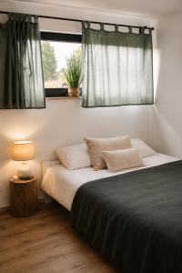a bedroom with a large bed with a window at Osada Przejrzysko in Jordanów