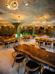 a restaurant with wooden tables and chairs and a room with barrels at Riverside Hotel & Restaurant in Acharistsqali