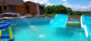 ein Schwimmbecken mit zwei blauen Plastikstühlen darin in der Unterkunft Sunset Oasis in Dătăşeni