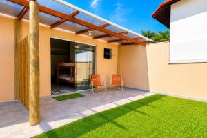 a house with a patio with orange chairs at Chalés & Suítes Praia Barequeçaba I Cozinha Compacta in São Sebastião