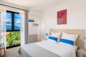 a bedroom with a bed with blue and white pillows at Villa Aster in Coti-Chiavari