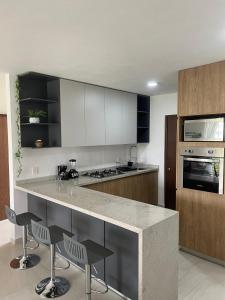 a kitchen with white cabinets and a counter with chairs at Villa Evelia, Pool, Near Nuevo Vallarta in Mezcales