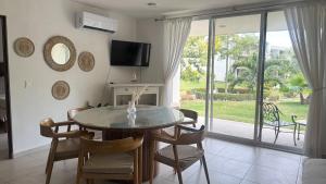 a dining room with a table and chairs and a television at Villa Evelia, Pool, Near Nuevo Vallarta in Mezcales