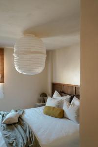 a bedroom with a white bed with a yellow pillow at Playa del Ter in Platja de l'Arenal