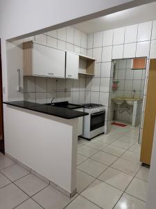 a kitchen with white cabinets and a counter top at Prédio Solar da Serra in Parauapebas