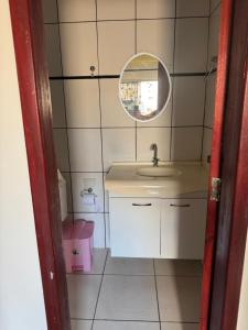 a small bathroom with a sink and a mirror at Prédio Solar da Serra in Parauapebas