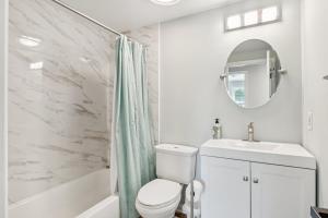 a bathroom with a toilet and a sink and a mirror at Renovated 3BR Near Sandy Point Beach in Annapolis +31 photos