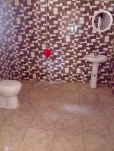 a bathroom with a toilet and a sink at Baraka Nema Villa Resorts in Gunjur