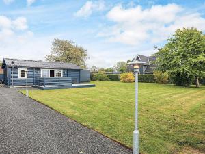 a blue house with a yard and a street light at 4 person holiday home in Assens in Assens