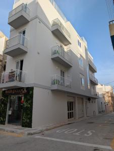 a white building with balconies on the side of it at Shamrock Flats in Mellieħa