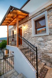 a stone house with a wooden roof and stairs at Villa Arty in Limenaria