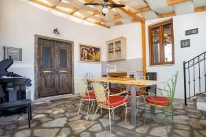a room with a table and chairs and a piano at Villa Arty in Limenaria +40 photos