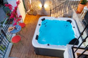 a hot tub on a deck with a table and chairs at Villa Arty in Limenaria