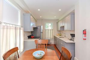 a kitchen with a wooden table and chairs and a kitchen with white cabinets at Pigeon Hill in Rockport