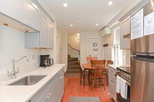 a kitchen with white cabinets and a table with chairs at Pigeon Hill in Rockport +19 photos