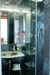 uma casa de banho com uma cabina de duche em vidro e um lavatório. em Locanda Tramonti em La Spezia