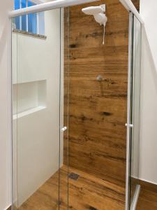 a glass shower door with a wooden wall at Casa da Marquês in Petrópolis +46 photos
