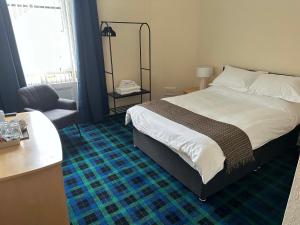 a bedroom with a bed and a desk and a chair at Waverley Hotel in Bonnyrigg