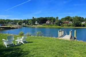 a couple of chairs sitting on the grass near a lake at River Watch in Gloucester