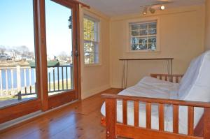 a bedroom with a bed and a balcony at River Watch in Gloucester