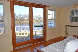 a bedroom with a large wooden door with a balcony at River Watch in Gloucester