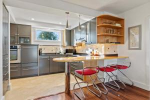 a kitchen with a wooden table and red chairs at Spa Creek Waterfront Pool & Parking in Annapolis