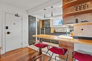 a kitchen with a counter with red chairs in it at Spa Creek Waterfront Pool & Parking in Annapolis +36 photos