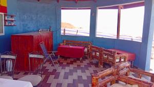 a room with a table and chairs and windows at Baraka Nema Villa Resorts in Gunjur