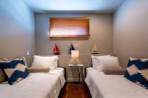 two beds in a small room with a window at Captains Quarters Waterfront & Pool in Annapolis