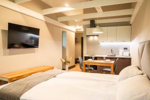 a bedroom with a bed and a table and a kitchen at Livonia Central Apartments in Valga
