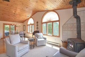 a living room with a wood ceiling and a stove at Wingaerchic in Gloucester