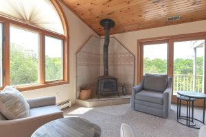 a living room with a fireplace and a chair and a stove at Wingaerchic in Gloucester