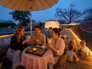 a group of people sitting at a table with drinks at Beijing Templeside Courtyard Hotel 丨 3 metros to the Square丨Free laundry, personalized services large terrace in Beijing
