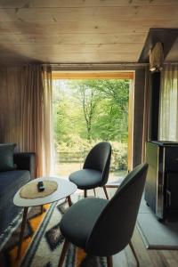 a living room with two chairs and a table and a window at Shale Maidan in Maidan Village