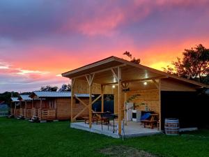 Eine Holzhütte mit Sonnenuntergang im Hintergrund in der Unterkunft Lark Nest in Novaci-Străini