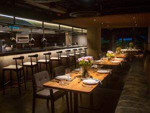 a restaurant with wooden tables and chairs and a bar at Oliver Mexico City in Mexico City